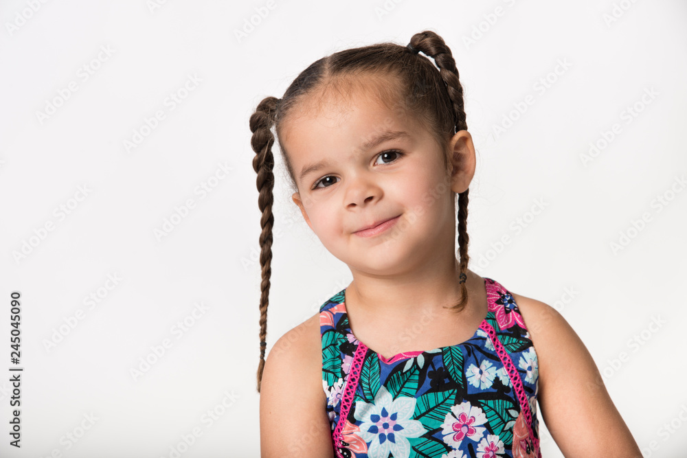 Wall mural mixed race preschooler with brown pigtail braids and playful expression