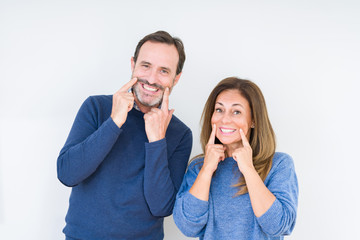 Beautiful middle age couple in love over isolated background Smiling with open mouth, fingers...
