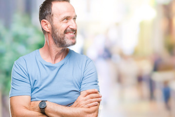 Fototapeta premium Middle age hoary senior man over isolated background looking away to side with smile on face, natural expression. Laughing confident.