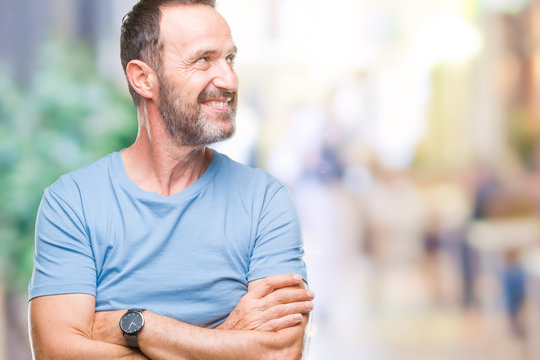 Middle age hoary senior man over isolated background looking away to side with smile on face, natural expression. Laughing confident.