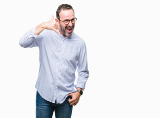 Fototapeta premium Middle age hoary senior man wearing glasses over isolated background smiling doing phone gesture with hand and fingers like talking on the telephone. Communicating concepts.