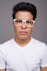 Obraz premium Portrait of young Asian man against gray background