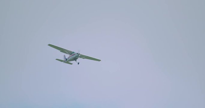 Small private plane flying in slow motion. No markings or identification.