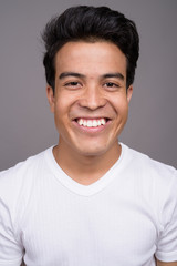 Fototapeta premium Portrait of young Asian man against gray background