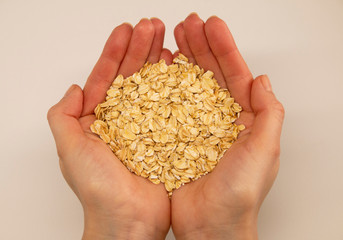 oat grain in the palms on a white background, top view