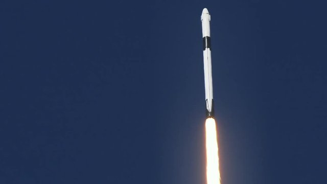 Space rocket or ICBM missile soars into space with bright trail of white smoke and exhaust in a clear blue sky.  120 fps slow motion. With audio.