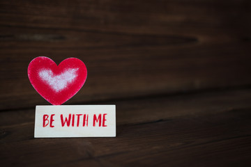 red heart on wooden background. Valentine's Day. celebration. the inscription on the plate "be with me"