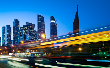 Modern office buildings with light trails of night traffic