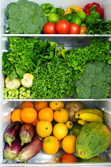 Opened fridge full of fresh colorful fruits and vegetables