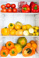 Opened fridge full of fresh colorful fruits and vegetables