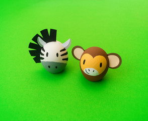 Easter holiday concept with cute handmade eggs: monkey and zebra.