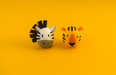 Easter holiday concept with cute handmade eggs: orange tiger and zebra.