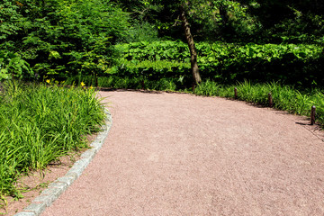 granite walkway for walking in the park with flowers and trees, nobody close-up.