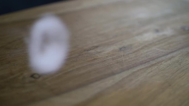 Vape trick blowing circle of smoke on wooden surface. Slow Motion