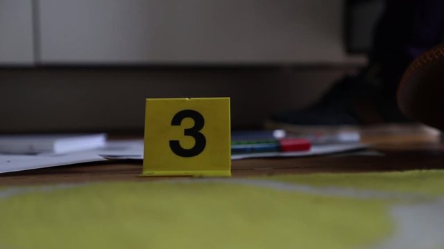 Crime Scene Unit officer numbering evidence in an apartment.