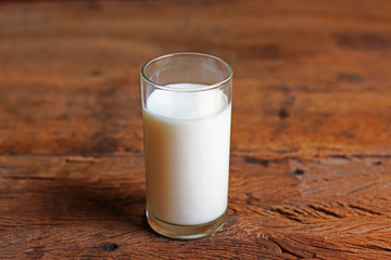 A glass of fresh  milk on wooden table 