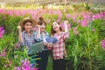 Asian girl group, flower farm, export, sell abroad Holding a notebook computer and a dollar Glad to succeed