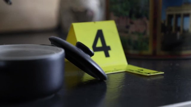 Crime Scene Unit officer numbering evidence in an apartment.