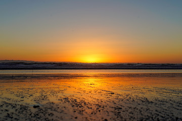 Bright orange serene beach sunset at low tide with no people