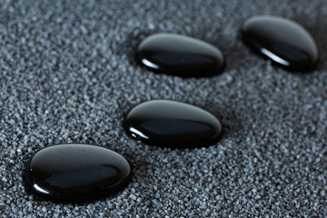 Stones with drops of water on a black background