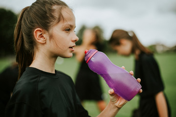 Female football player drinking from a water bottle