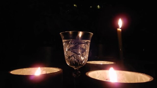 Full Glass Of Wine With Candles And Flames At Night