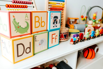 Set of kid toys on a white shelf - obrazy, fototapety, plakaty