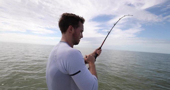 Fishing - man sport fishing big game shark fishing on boat in Florida. Travel tourist man catch and release of spinner shark. From Florida keys.