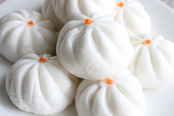 Steamed dumpling in a white dish, popular Chinese food.