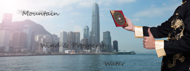 Fototapeta na wymiar Feng Shui Master show FengShui Compass and turn direction to Force Energy, He wear black shirt check Wind Qi flow, Mountain at Back and Water at Front, Good Dragon Emperor Perfect Location