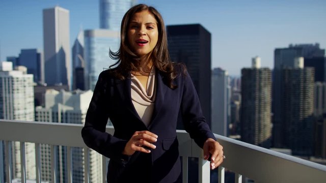 Portrait of Hispanic businesswoman on city rooftop overlooking cityscape Chicago