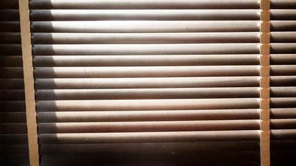 evening sun light outside with wooden window blinds, sunshine and shadow on window blind, decorative interior home concept 