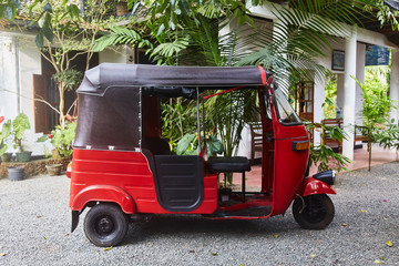 Red Tuk-tuk taxi on road of Sri Lanka. Ceylon travel car. rickshaw