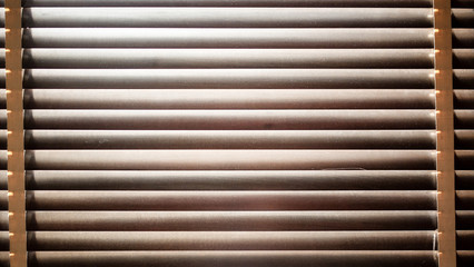 evening sun light outside with wooden window blinds, sunshine and shadow on window blind, decorative interior home concept 