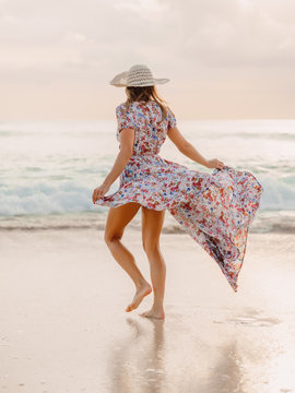 Life style woman in dress on beach at sunset or sunrise. Feminine style.