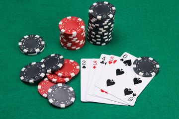 game set of poker cards, for playing big bets, on a green table, surrounded by chips