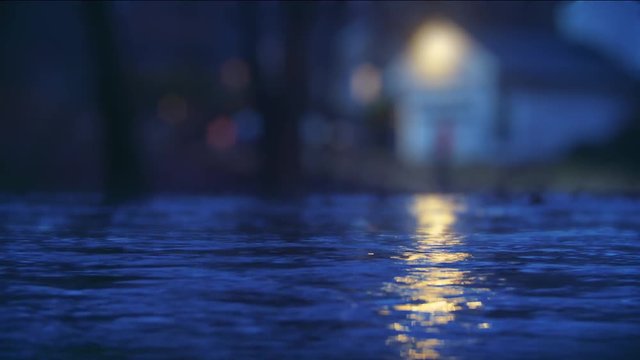 Rising flood waters encroach on the front steps of a nearby home at night
