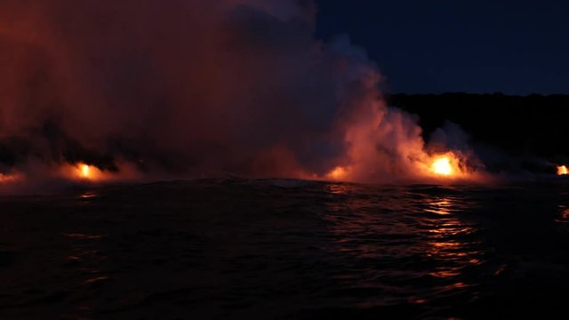 Lava running in the ocean from volcanic lava eruption on Big Island Hawaii. Seen from lava boat tour. Lava from Kilauea volcano by Hawaii volcanoes national park, USA. Dawn, steadicam, 59.94 FPS.
