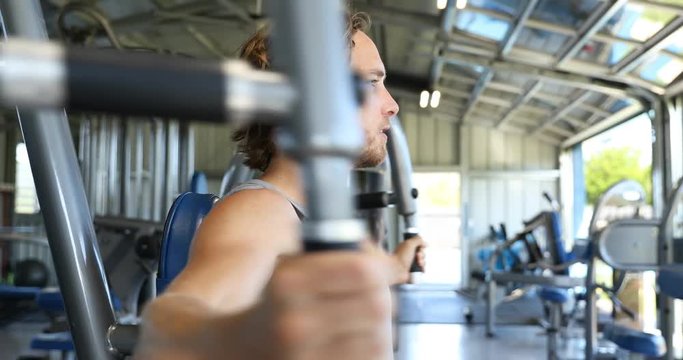 Fitness man at gym doing butterfly chest workout on fitness fly machine