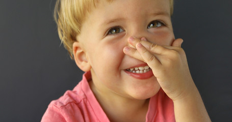 Pretty boy hand presses his nose like a button on a gray background. He points his fingers on his...