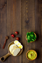 Healthy breakfast. Toasts with vegetables and guacamole on dark wooden background top view copy space
