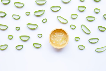 Aloe vera slices with aloe vera gel in wooden bowl on white background.