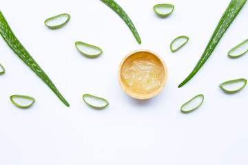 Aloe vera leaves and slices with aloe vera gel in wooden bowl on white background.