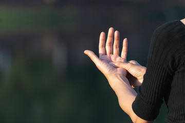 Closeup hand of person massage her hand from pain in healthy concept on nature background.