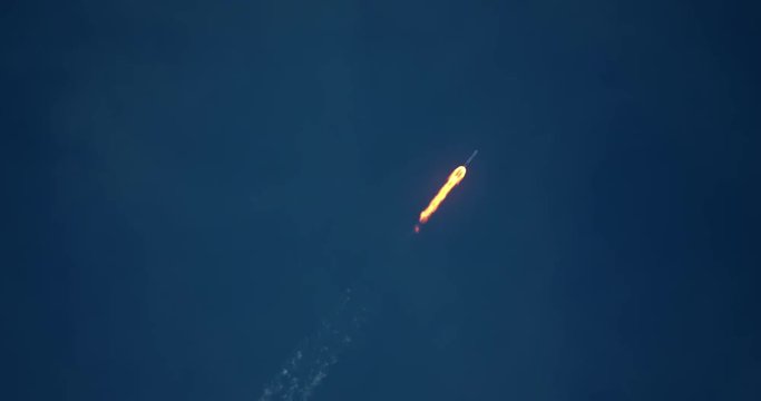 ICBM missile rocket flying into space with bright yellow exhaust flames and smoke in 4K.