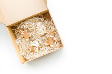 Order goods online concept. Cardboard box with gingerbread cookies on white background top view copy space