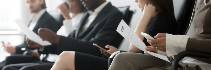 Horizontal side photo multinational applicants businesspeople sitting in queue waiting job interview holding resume papers using mobile phones, hr employment concept, banner for website header design - obrazy, fototapety, plakaty