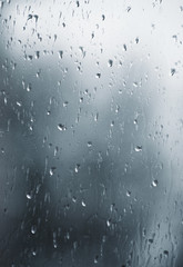 Rain drops on window glasses surface with bokeh background.