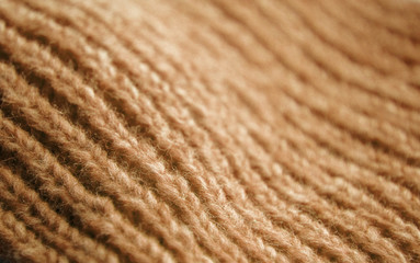 The texture of a knitted woolen fabric brown.
