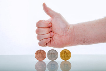 Three bitcoins on white background with hand